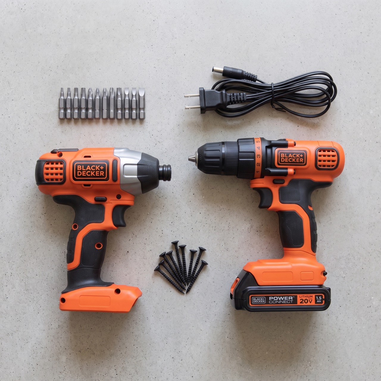 Overhead view of both tools laid out on bare concrete alongside driver bits and loose screws.